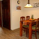 Esszimmer mit Holztisch, Stühlen und Obst. Durchgang zur Schlafzimmer mit Bett.