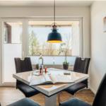 Esszimmer mit quadratischem Tisch, schwarzen Stühlen und Blick auf Außenbereich.