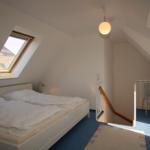 Bedroom with skylight, bed, and stairs to gallery.