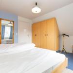 Bedroom with double bed, wardrobe, and mirror on the wall.