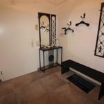 Entrance area with bench, mirror, and coat hooks on the wall.