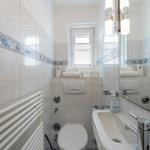 Bathroom with toilet, sink, and radiator on the wall.