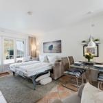 Sleeping room with sofa bed, dining area, and windows to outdoor terrace.