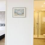 Schlafzimmer mit Bett und Badezimmer mit Dusche und Toilette