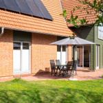 Haus mit Terrasse, Garten und Solaranlage. Außentisch mit Sonnenschutz.