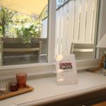 Balcony with table, chairs, and glasses. Information leaflet and lantern on the sill.