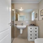 Badezimmer mit Waschbecken, Spiegelschrank und Dusche