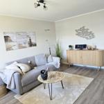 Living room with gray sofa, round table, and wooden cabinet.