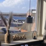 View from window to beach and parking lot with solar panels.