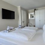 Room with double bed, TV, wardrobe, and mirror.