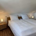 Schlafzimmer mit Doppelbett, zwei Nachttischen und Lampen an der Wand.