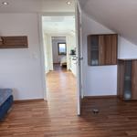 Schlafzimmer mit Holzboden und Blick in die Küche