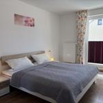 Schlafzimmer mit Doppelbett, Nachttisch und Fenster mit Blenden.