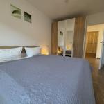Schlafzimmer mit Doppelbett, Kleiderschrank und Blick in die Dusche.