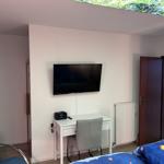 Schlafzimmer mit Schreibtisch, Fernseher und Bett unter Glasdach