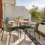 Terrace with round table and four chairs, view of green trees