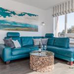 Living room with blue sofa, round table, and wall art.