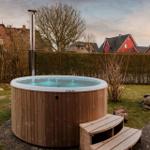 Hochwertiger Whirlpool mit Holzrahmen und integriertem Ofen im Garten