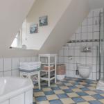 Badezimmer mit Dusche, WC, Badewanne und Fenster unter Dachschräge.