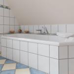 Badezimmer mit Dusche und Badewanne, gefliest mit blau-weißen Fliesen.