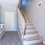 Haus mit Treppe, weiße Tür und Sitzbank mit Kasten