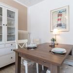 Esstisch mit Stühlen, Sideboard und Leuchte an der Wand.