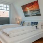 Schlafzimmer mit Doppelbett, Fenster und Wandbild.