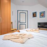 Schlafzimmer mit TV und Doppelbett (OG)