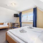 Schlafzimmer mit Doppelbett und einem Einzelbett