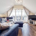 Wohnbereich mit Sofa, Sessel und TV
