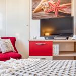 Blick zum TV und Sessel im Schlafzimmer
