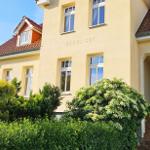 Haus Nordlicht mit Eingang und Garten. Fenster und Dach sichtbar.