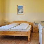 Schlafzimmer mit Bett, Tisch, Küchenzeile und Fenster