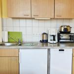 Küche mit Spüle, Kühlschrank, Spülmaschine, Kaffeemaschine und Toaster.