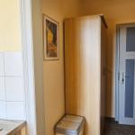 Küche mit Toaster und Kühlschrank, daneben Schrank und Tür