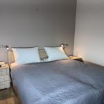 Schlafzimmer mit Bett, zwei Nachttischen und Wandbild