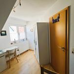 Ein Zimmer mit Schreibtisch, Fenster, Kleiderschrank und Tür mit Dekoration.