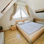 Doppelbettzimmer mit Dachschrägen, Fenster und Holzboden.