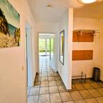 Hallway with tiled floor, wall picture, mirror, and coat area with hooks.