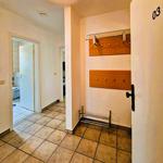 Entrance area with coat rack, shoe rack, and view into bathroom and kitchen.