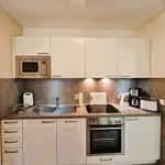Kitchen with white cabinets, stove, sink, and microwave.