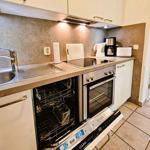 Kitchen with sink, range hood, stove, oven, and dishwasher.