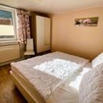Bedroom with bed, wardrobe, and window. Wall art with flowers.