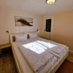 Bedroom with double bed, wooden floor, and wall art.