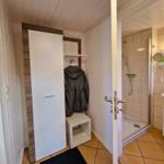 Hallway with closet and view into the shower