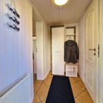 Hallway with rug, coat stand, and wall decoration