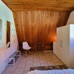 Bedroom with wooden ceiling, white closet, and bed in foreground.