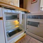 Refrigerator with open door and visible compartments in the kitchen