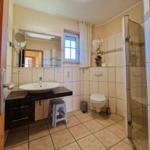 Bathroom with shower, toilet, sink, and window