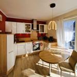 Kitchen with dining area, wooden floor, and window to terrace.